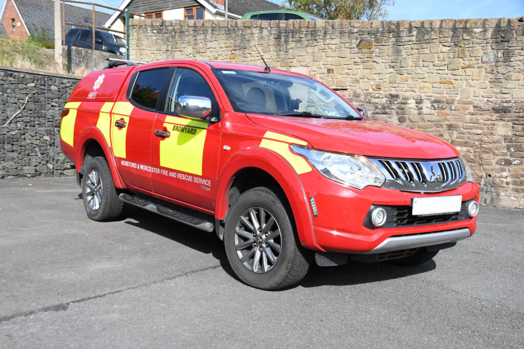 crew carrier on forecourt of fire station with brick wall behind