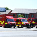 Three fire vehicles in front of fire station