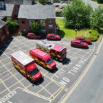 Three fire vehicles and car fleet taken from above