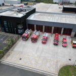Line up of six vehicles at front of fire station taken from above