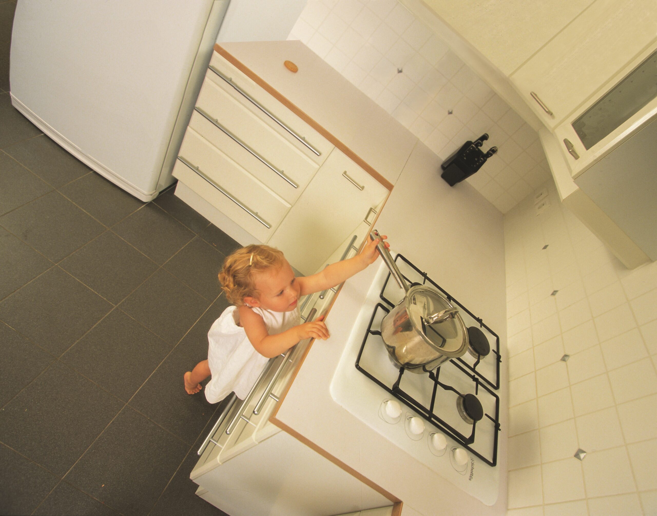 Child reaching for pan on the hob.