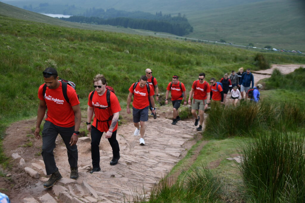 Stu's phoenix Challenge - a number of people in red t-shirts climbing a hill