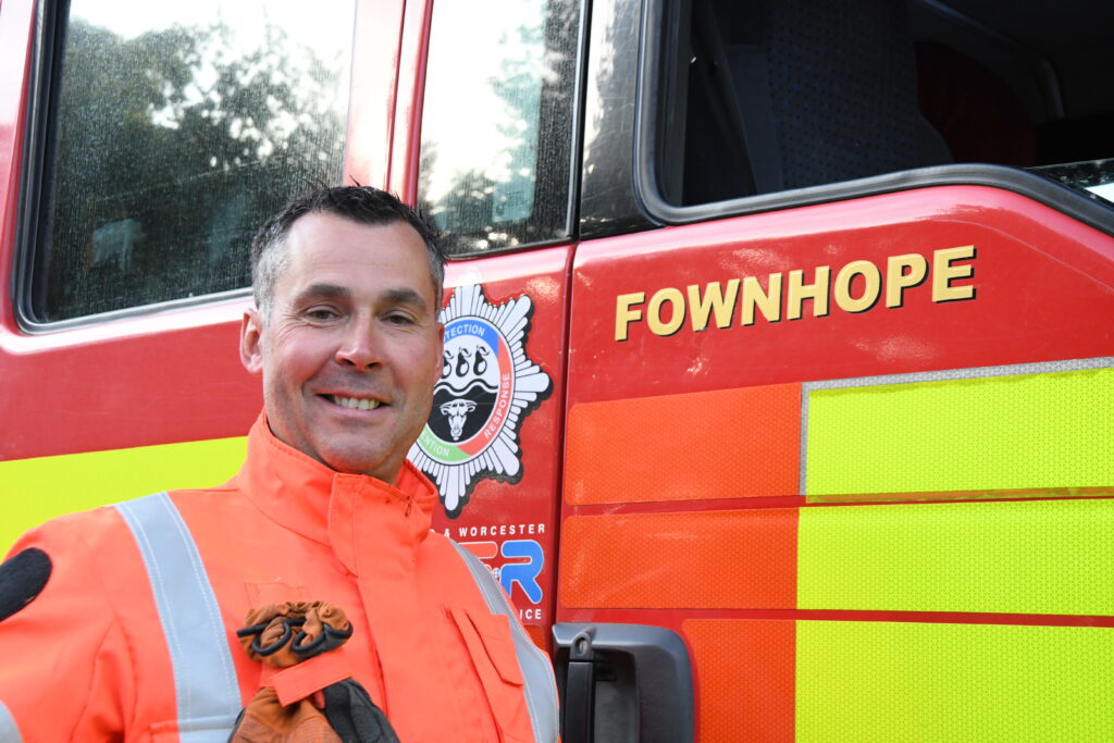 Firefighter in RTC kit in front of fire engine