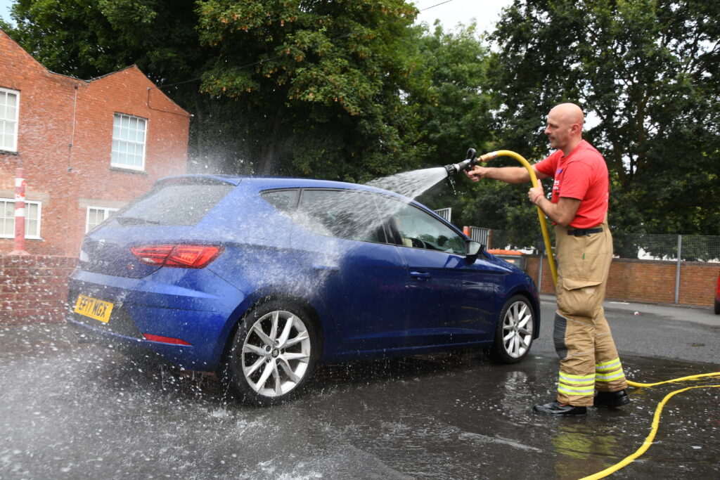 Firefighter washing blue car